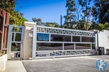 Custom Tinted Glass Sliding Driveway Gate with Ornamental Design and Framing